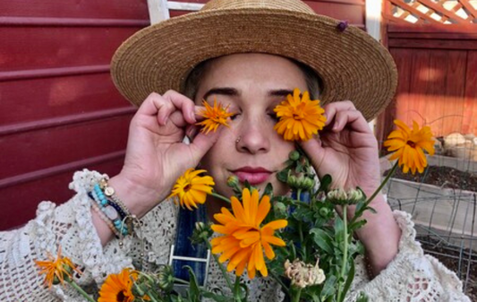 Photo of Woman with Calendula Flowers in Garden