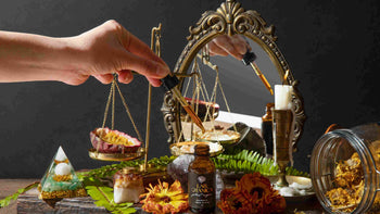 Dropper applying Alchemic Elixir with passionfruit and healing herbs on a balance scale, reflecting the harmony of plant-powered beauty rituals.